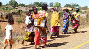 mujeres africanas con sus hijos andando por una carretera